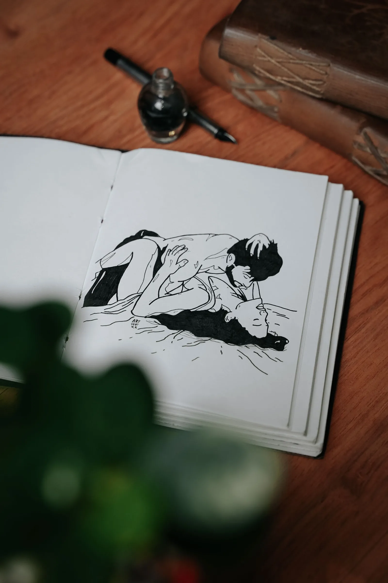 Black ink drawing of two people in a sketchbook
