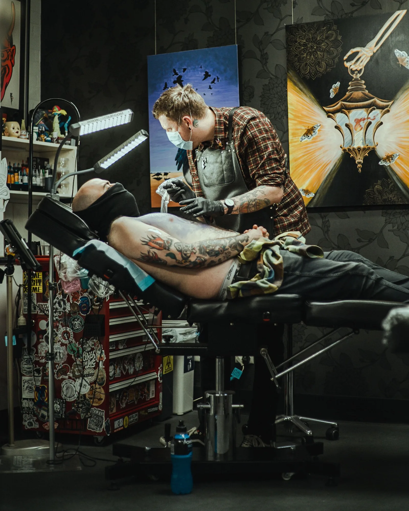 An artist at work in a studio full of framed drawings
