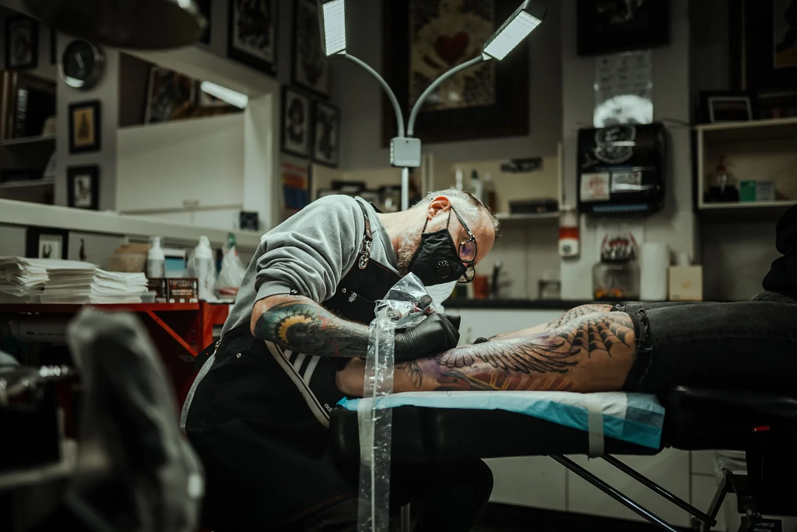 A leg piece being tattooed in a bright studio