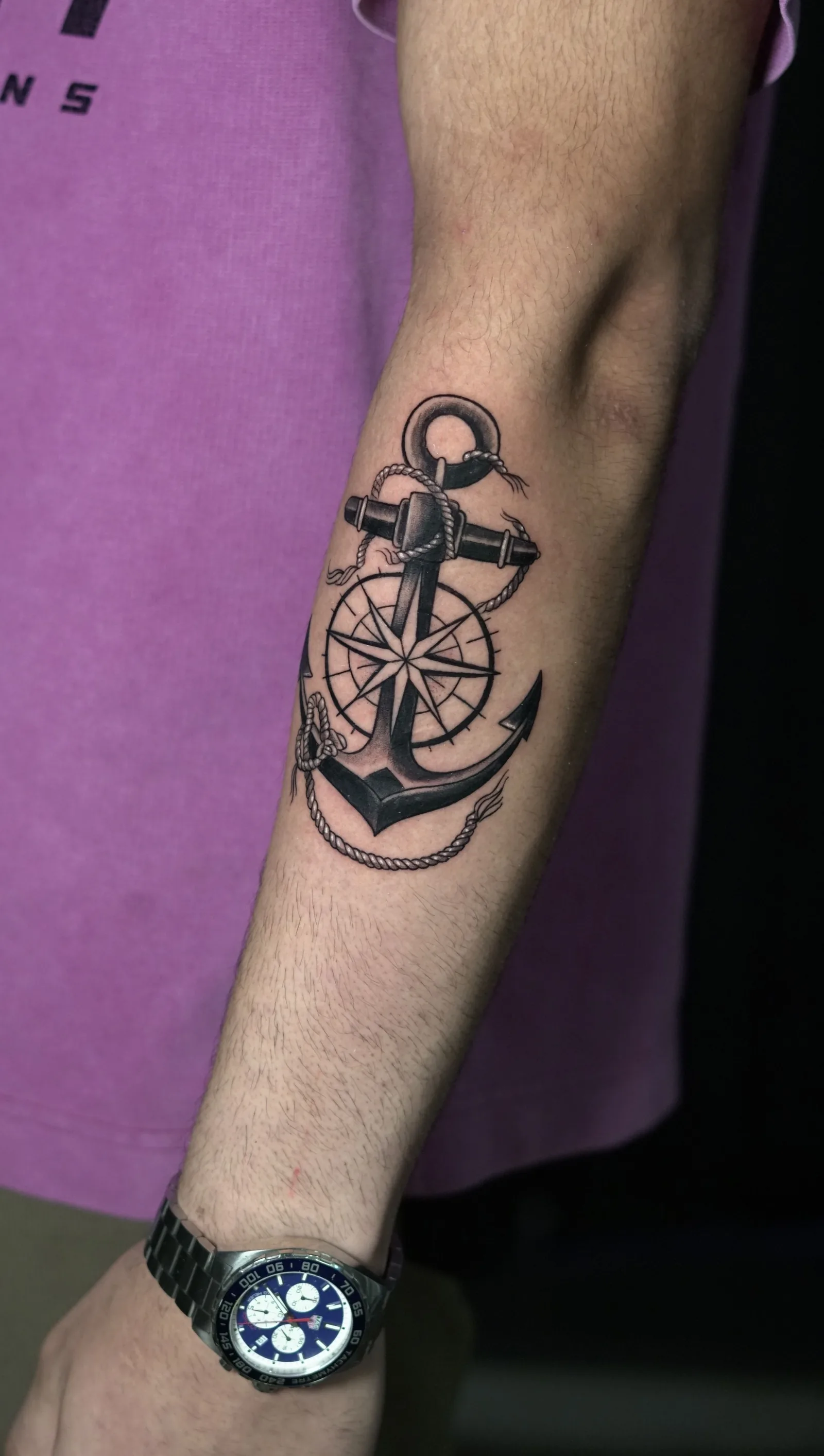Anchor and compass tattoo on a forearm