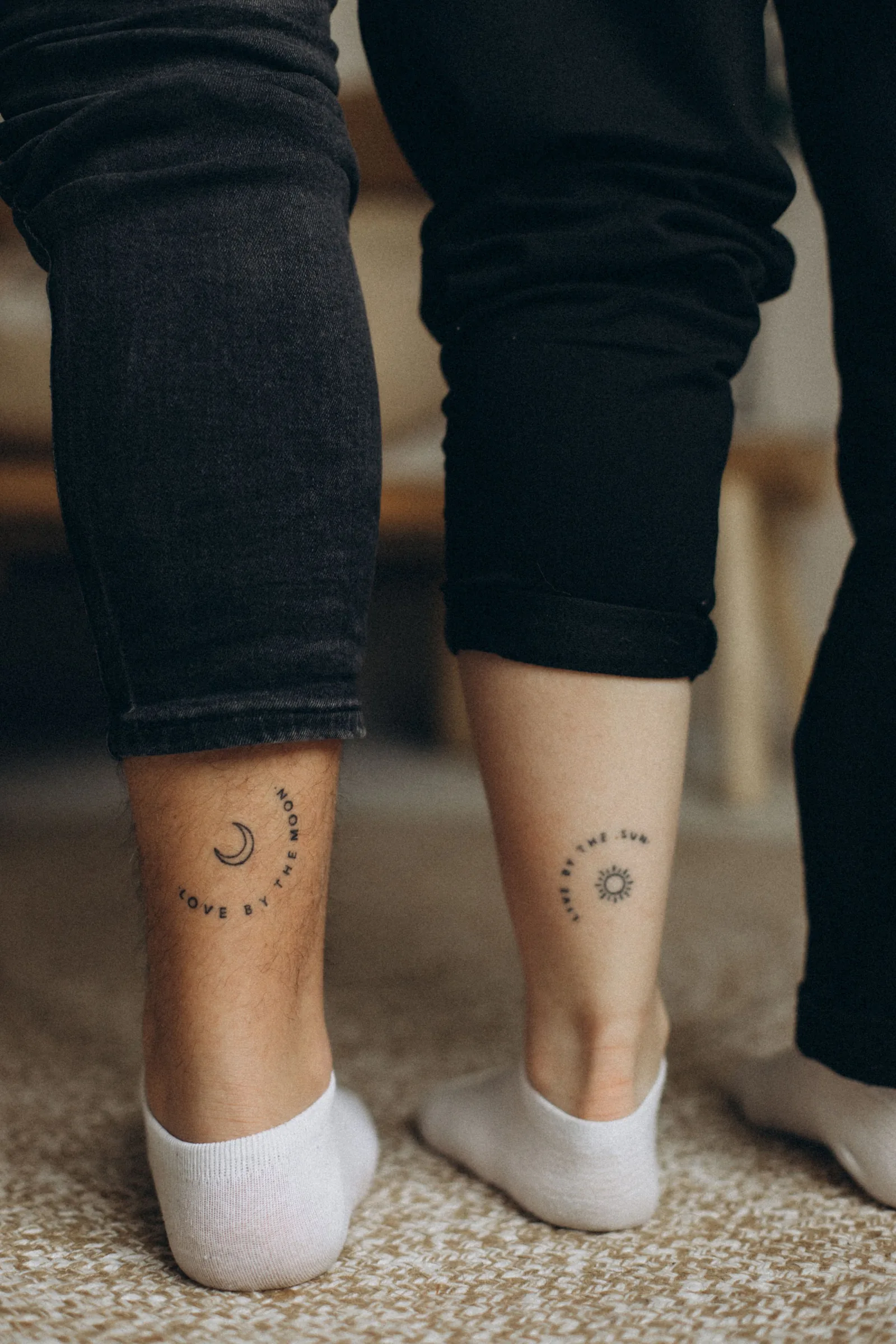 Small moon and sun tattoos on two ankles