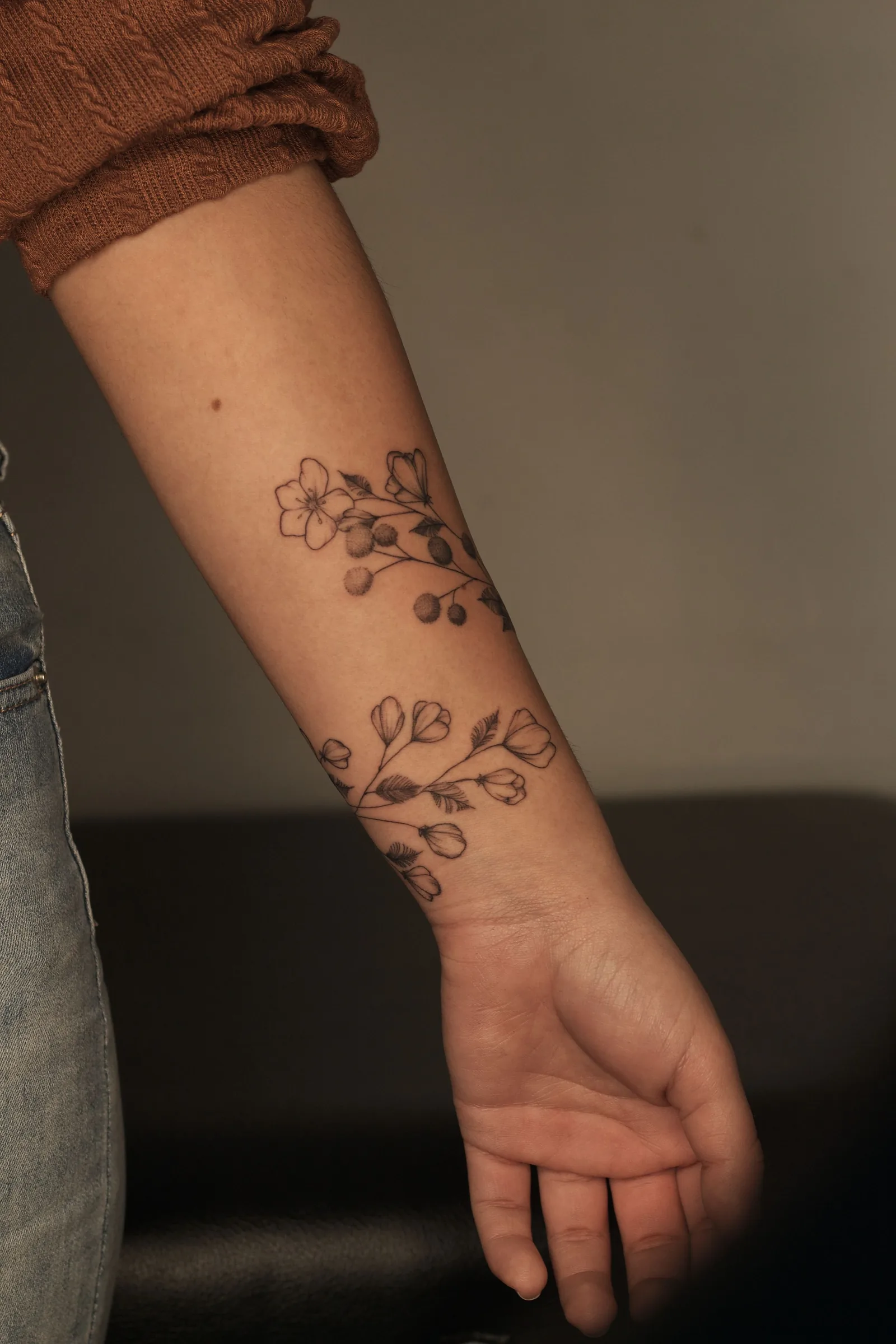 Floral branch tattoo on a forearm