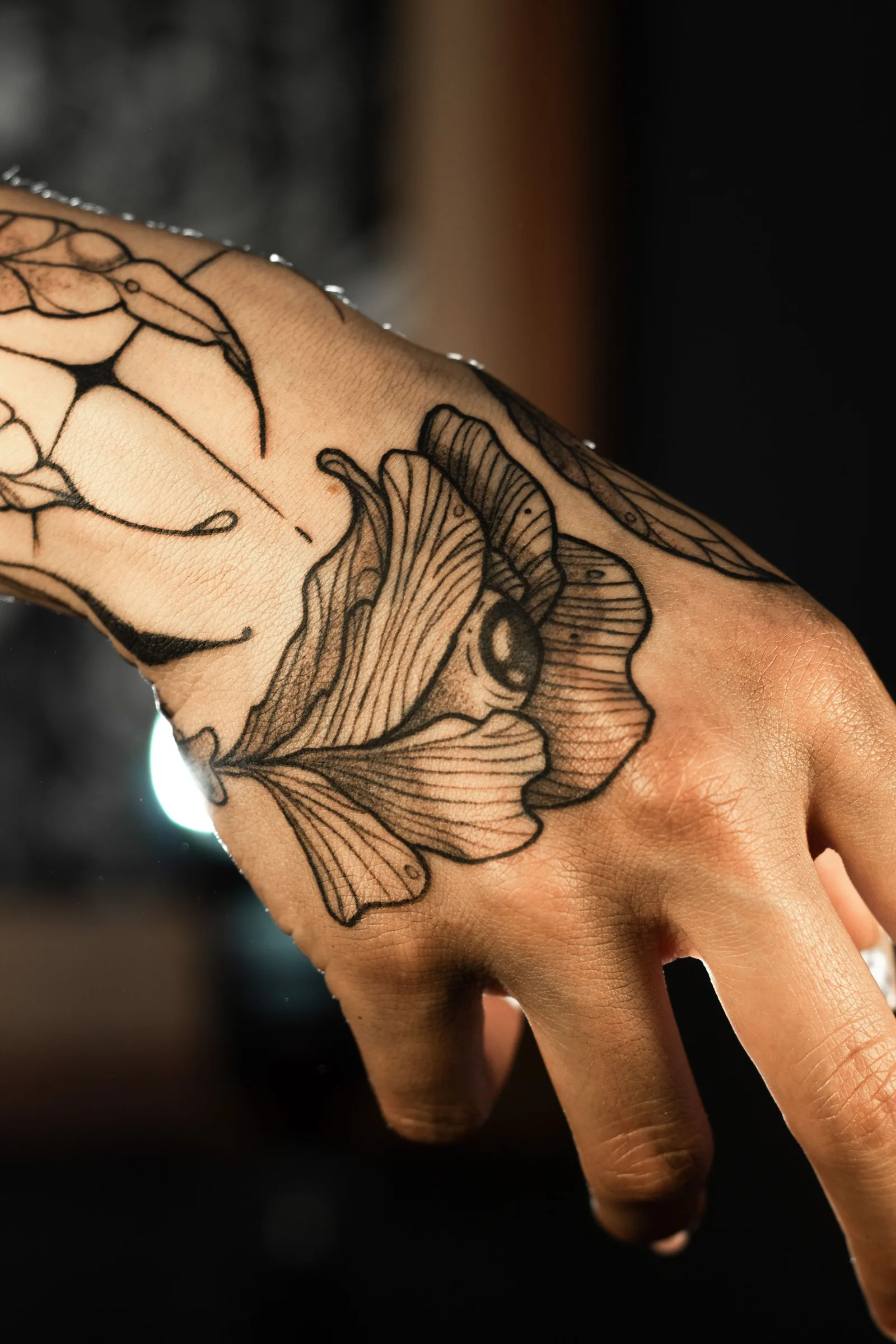 Large flower tattoo across the back of a hand