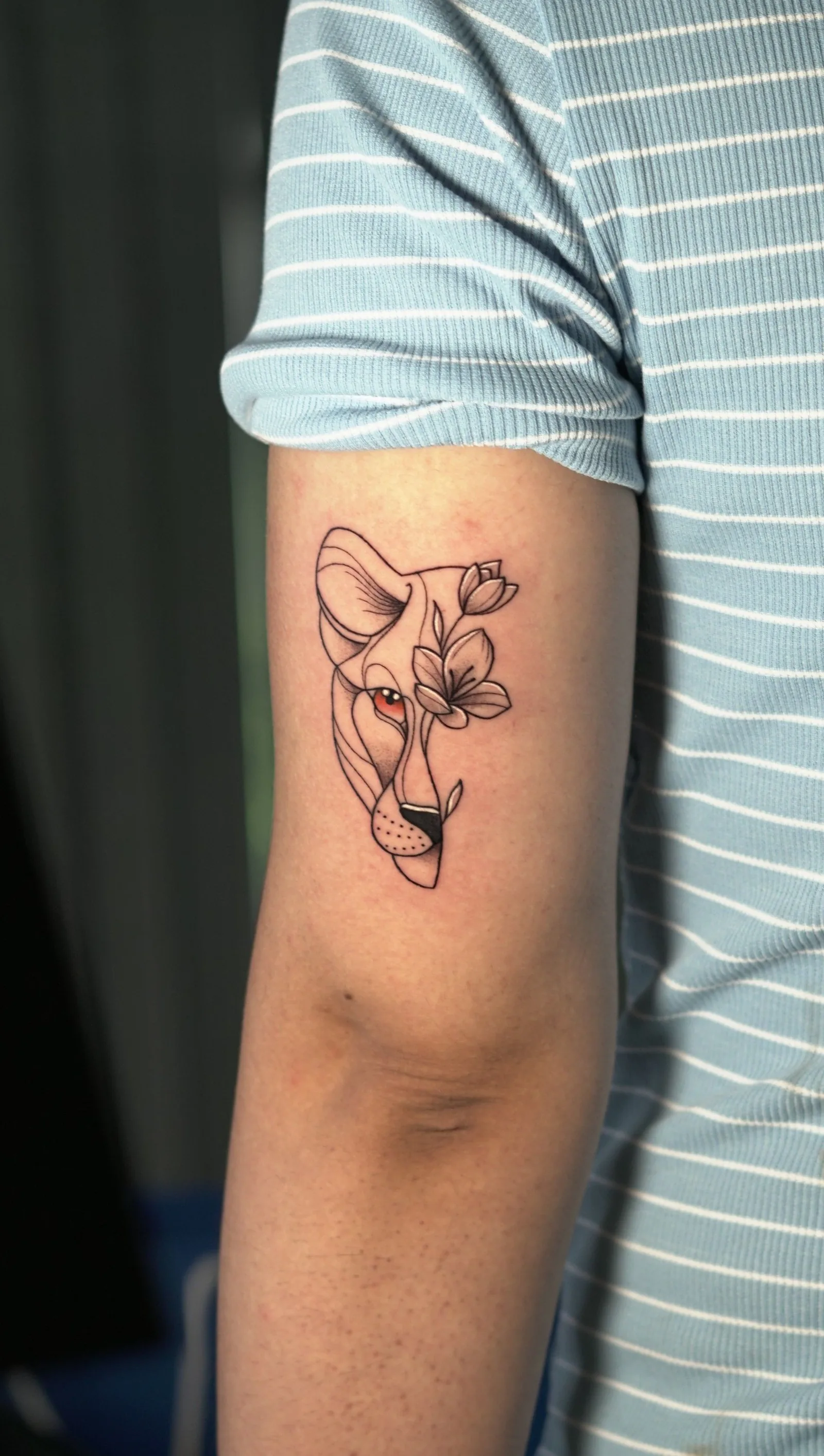 Fine line wolf with flowers on an upper arm